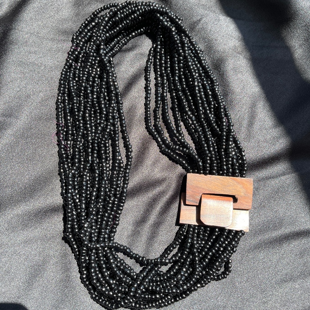 Beaded necklace with wooden clasp, artisnal, in black.